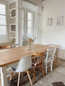 a dining room with a wooden table and chairs at Logis du Chandelier in Le Puy en Velay