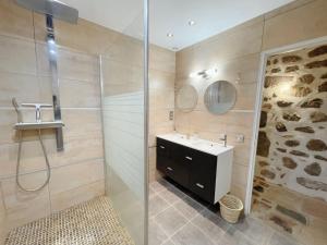 a bathroom with a sink and a glass shower at Logis du Chandelier in Le Puy en Velay