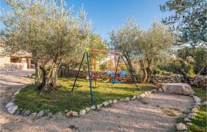a swing set in a yard with trees at 2 Bedroom Pet Friendly Home In Silo in Šilo