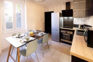 uma cozinha com uma mesa e cadeiras numa cozinha em L'Urbain B - Tout équipé - Centre-Ville Gare em Montluçon