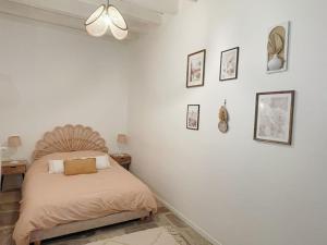 a bedroom with a bed and some pictures on the wall at Logis du Chandelier in Le Puy en Velay