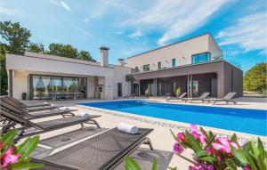 a house with a swimming pool and lounge chairs at 5 Bedroom Beautiful Home In Kujici in Hreljići