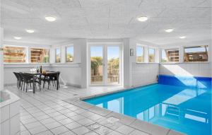 エーベルトフトにあるAwesome Home In Ebeltoft With 6 Bedrooms, Private Swimming Pool And Indoor Swimming Poolのダイニングルームとテーブル付きの家のスイミングプールを利用できます。