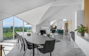 a dining room and living room with a table and chairs at Awesome Home In Ebeltoft With 6 Bedrooms, Private Swimming Pool And Indoor Swimming Pool in Ebeltoft