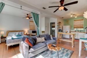 a living room with a blue couch and a kitchen at Spanish Bungalow Guest House in Daytona Beach