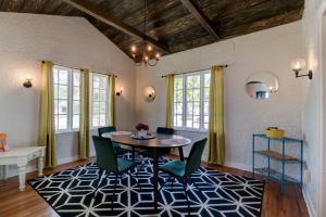 a dining room with a table and chairs on a rug at Spanish Beach Bungalow MainHouse in Daytona Beach