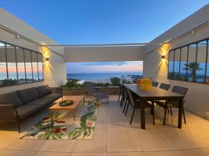 een woonkamer met een bank en een tafel bij Superbe T2 44m2 - Grande terrasse Vue mer panoramique exceptionnelle Piscine - Parking in Bandol