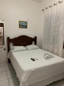 1 dormitorio con 1 cama con sábanas blancas y ventana en Pousada Vilas Boas, en Barreirinhas