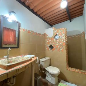a bathroom with a toilet and a sink and a mirror at La Qhia Eco Retreat in Santa Fé +50 photos