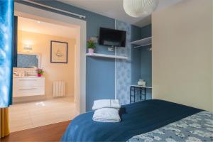 a bedroom with blue walls and a bed with towels at Escale et bien-être in Pornic