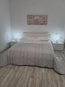 um quarto com uma cama grande e piso em madeira em Casa Rosy em Lucera