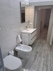 Casa Rosy في لوتشرا: حمام به مرحاض أبيض ومغسلة