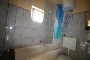La salle de bains est pourvue d'une baignoire, de toilettes et d'une fenêtre. dans l'établissement Apartman Zaton, à Zaton