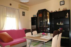 a living room with a pink couch and a table at Apartman Zaton in Zaton