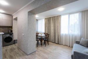 sala de estar con sofá y mesa con sillas en Ninia's Apartment en Kutaisi