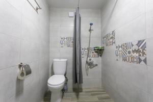 a bathroom with a white toilet in a stall at Ninia's Apartment in Kutaisi