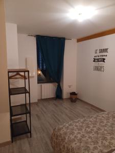 a bedroom with a bed and a blue curtain at la maison du bonheur in Saint-Germain-Laval