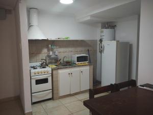 y cocina con fogones blancos y nevera. en Departamentos Centro Dpto 5 1 habitacion en Tandil