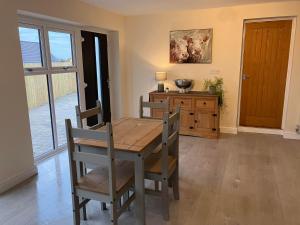 - une salle à manger avec une table et des chaises en bois dans l'établissement Honeyberry Cottage -PART OF ALTON COTTAGES, à Alton