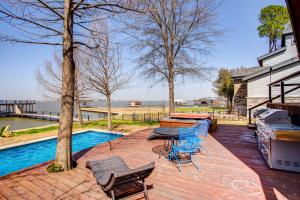 een patio met een tafel en stoelen en een zwembad bij Cedar Creek Lakefront Vacation Rental with Pool in Gun Barrel City