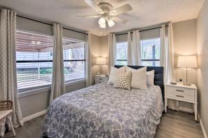 a bedroom with a bed with a ceiling fan and windows at Lake View and Decks Pet-Friendly Mabank Home in Mabank