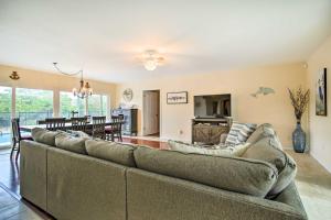 a living room with a large couch and a dining room at Riviera Beach Vacation Home with Pool Walk to Beach in Riviera Beach