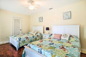 a bedroom with two beds and a ceiling fan at Riviera Beach Vacation Home with Pool Walk to Beach in Riviera Beach +26 photos