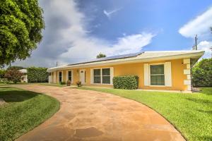 a yellow house with a brick driveway at Riviera Beach Vacation Home with Pool Walk to Beach in Riviera Beach
