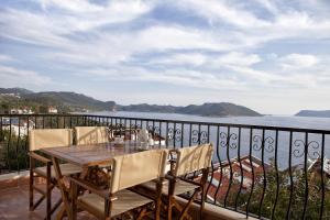 een tafel en stoelen op een balkon met uitzicht op het water bij Lantana Aparts in Kas