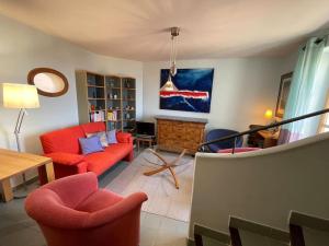 een woonkamer met een rode bank en stoelen bij Maison au cœur de Sablet & terrasse panoramique in Sablet