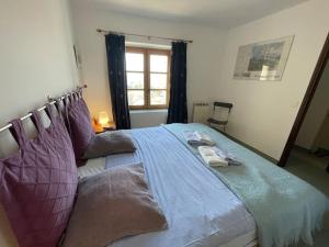 - une chambre avec un grand lit et des oreillers violets dans l'établissement Maison au cœur de Sablet & terrasse panoramique, à Sablet