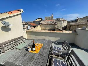 een fles wijn op een tafel op een balkon bij Maison au cœur de Sablet & terrasse panoramique in Sablet