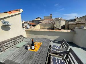 - une bouteille de vin assise sur une table sur un balcon dans l'établissement Maison au cœur de Sablet & terrasse panoramique, à Sablet