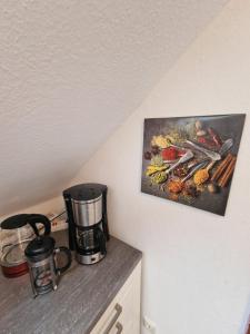 オーバーハウゼンにあるFewoFaubelCentro 42 & 54 & 62 m2のキッチン(コーヒーメーカー付)が備わります。壁に絵画が飾られています。