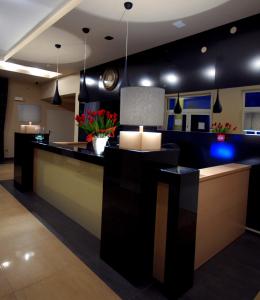 a lobby with a counter with a clock on the wall at Hotel Hibiskus in Boguchwała