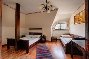 a bedroom with two beds and a mirror at Gościniec Oycowizna in Lesznowola