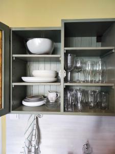 Veludo Apartments في بانسكا بيستريتسا: خزانة مليئة بالأطباق والكؤوس والأطباق