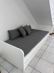 uma cama branca com almofadas num quarto em El Mensú Loft em Posadas