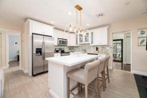 a kitchen with white cabinets and a large white island at Home at Poinsettia Heights in Fort Lauderdale
