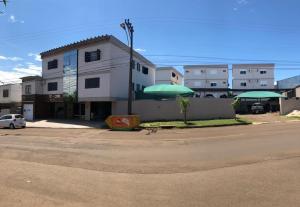 イジュイーにあるApart-Hotel Ijuíの通りに並ぶ緑の傘2本の建物