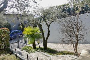 une maison avec une clôture et un arbre dans une cour dans l'établissement Sarnico giardino sul lago, à Sarnico