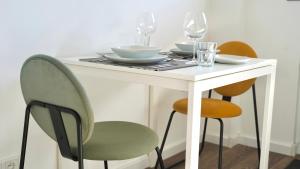 a white table with plates and glasses on it at Zentral & Modern Nähe Düsseldorf und Köln in Wuppertal