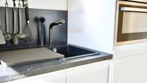 a kitchen counter with a sink and some utensils at Zentral & Modern Nähe Düsseldorf und Köln in Wuppertal +24 photos