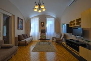 ein Wohnzimmer mit einem Sofa und einem TV in der Unterkunft Demetrovics Udvarház in Eger