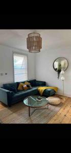 a living room with a blue couch and a glass table at Stylish property, off street parking,pet friendly in Bath