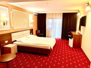 Habitación de hotel con cama y alfombra roja en Complex Azar, en Galaţi