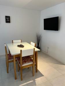 mesa de comedor con 2 sillas y TV en Departamento en Mar del Plata centro en Mar del Plata