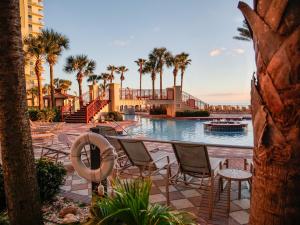 una piscina in un resort con sedie e palme di Shores of Panama 804 a Panama City Beach