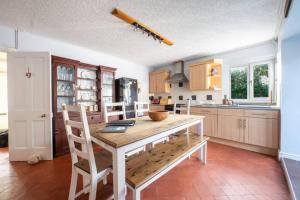 a kitchen with a wooden table and chairs in it at Cosy Welsh Cottage in St Davids Centre with Garden in St. Davids