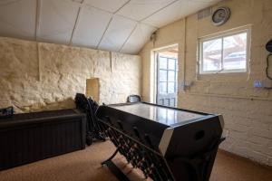 an empty room with a ping pong table in it at Cosy Welsh Cottage in St Davids Centre with Garden in St. Davids